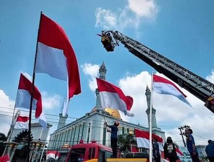 Unik dan Khidmat! Bendera Raksasa Berkibar di Atas Mobil Tangga Damkar Setinggi 20 Meter di Simpang Lembuswana